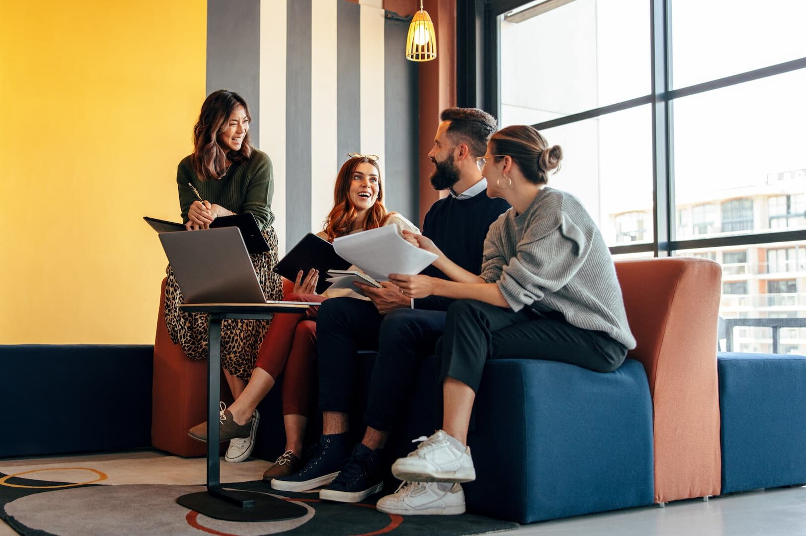 four people sitting no a couch working on a team project